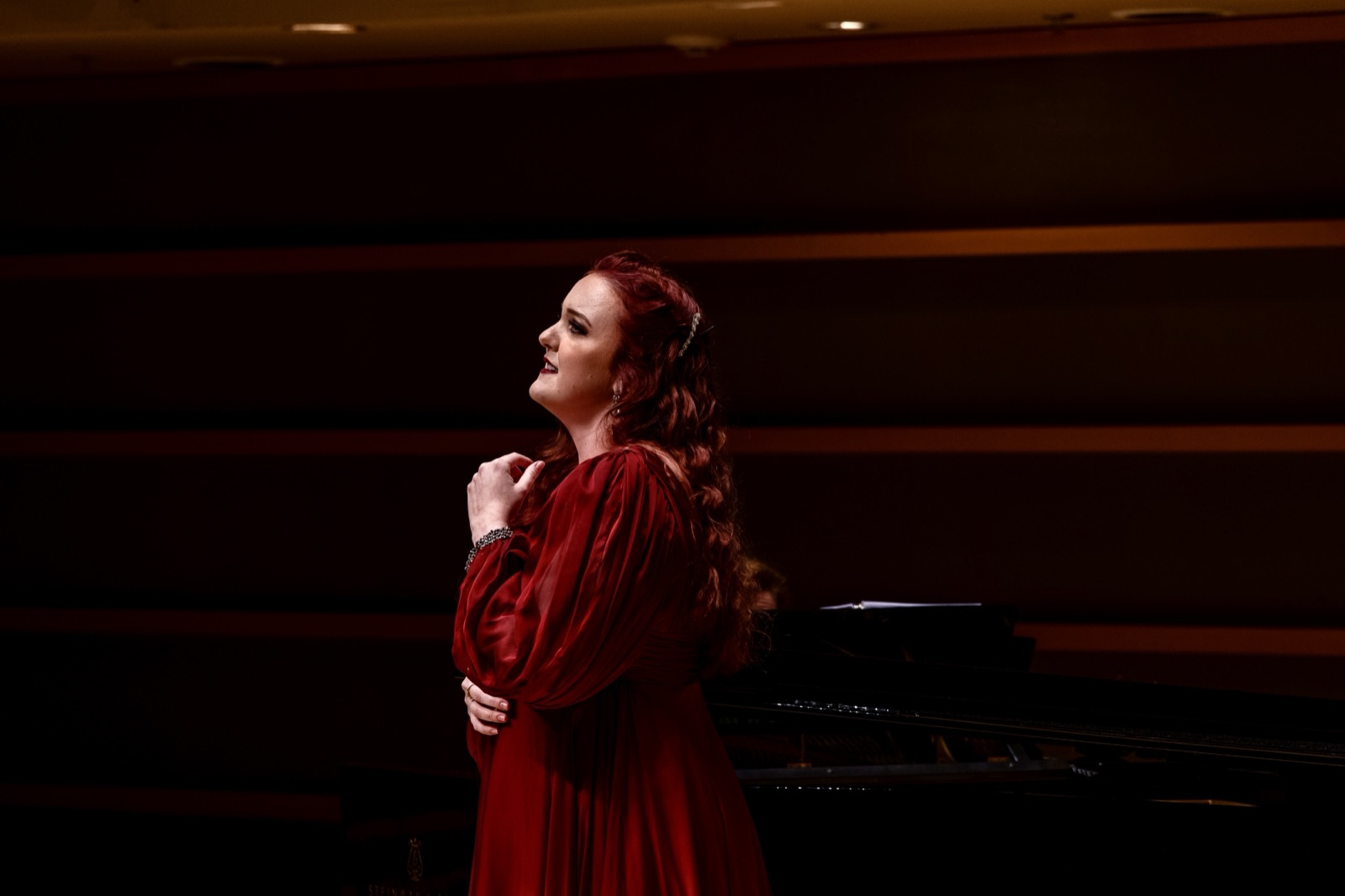 Veronica Richer in a red gown in profile