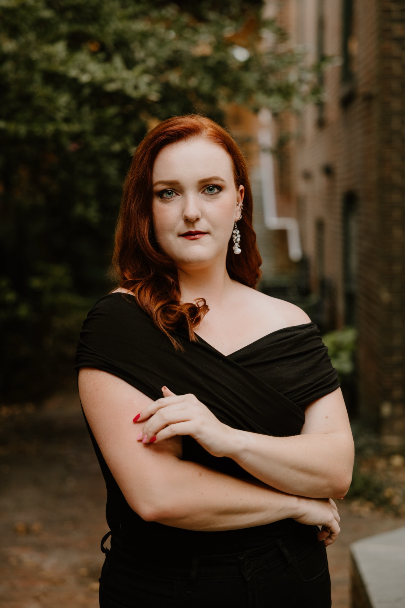 Veronica Richer, arms folded, in a black off-the-shoulder gown